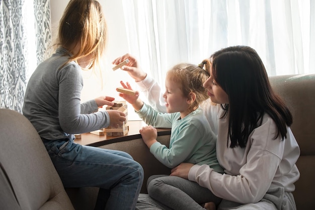 Niños jugando un juego de mesa con palos de madera en casa