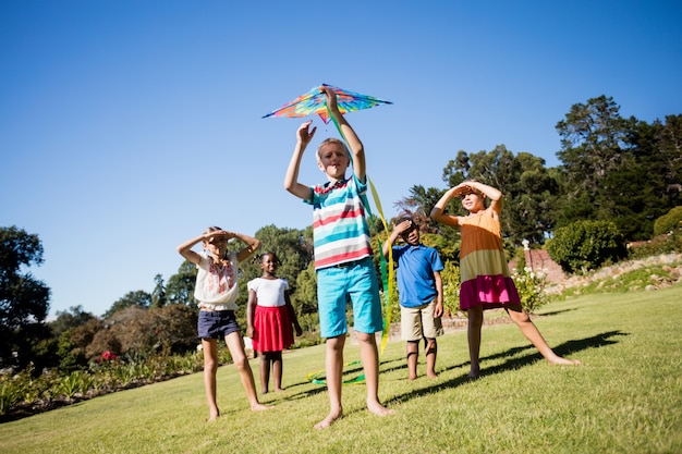 Niños jugando juntos durante un día soleado con una cometa