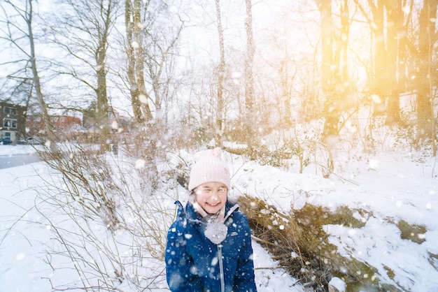 Niños jugando en la nieve en invierno niños felices riendo en el hermoso bosque de invierno cubierto de nieve en