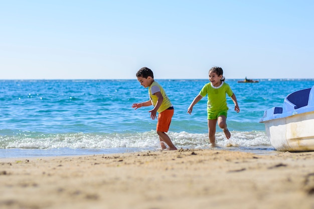 Niños jugando en la orilla del mar bajo la luz del sol