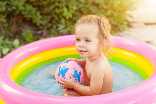 Niños jugando en la piscina inflable para bebés.