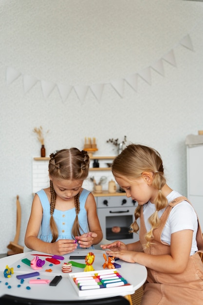 Foto niños jugando con plastilina