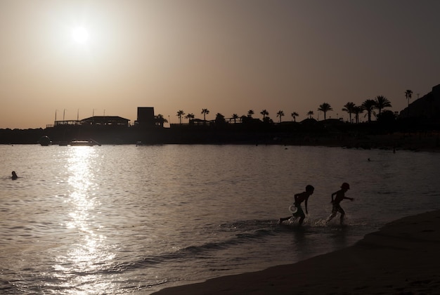 niños jugando en una playa española al atardecer