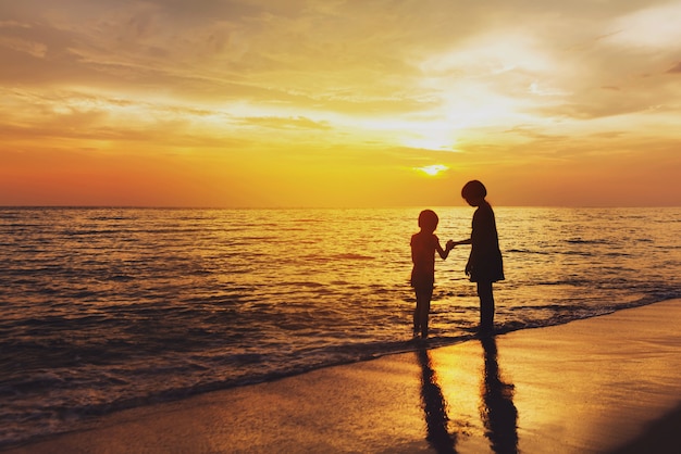 niños jugando en la playa en el momento del amanecer