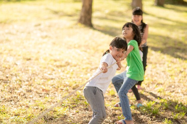 Niños jugando tira y afloja en el parque en sunsut.