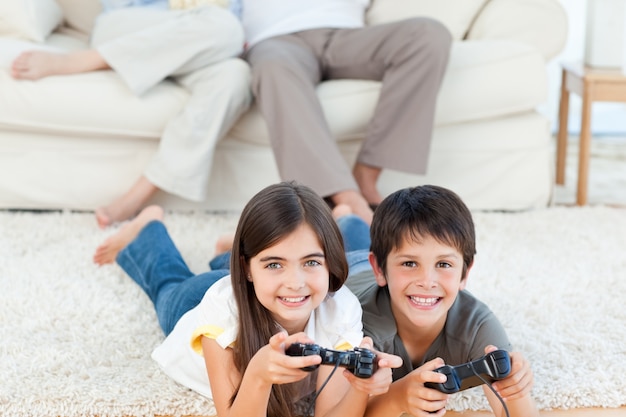 Niños jugando videojuegos mientras los padres hablan