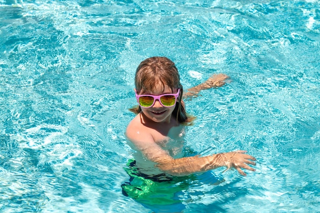 Niños juguetes de agua los niños juegan en un resort tropical niño en la piscina jugando en el agua vacaciones a