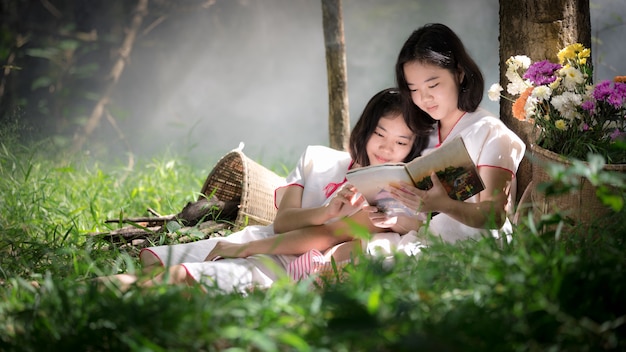 niños karen leyendo un libro en el medio del bosque