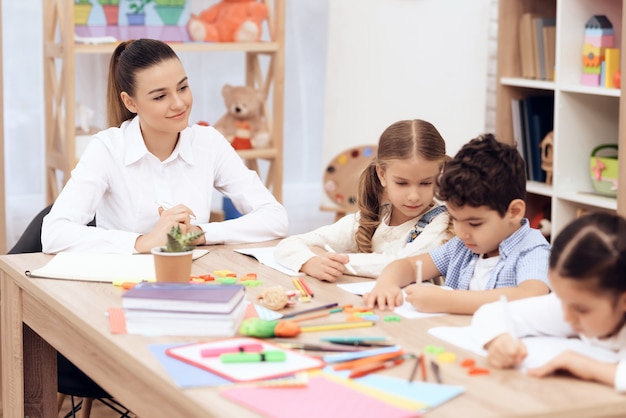 Los niños de kindergarten aprenden a dibujar con lápices.