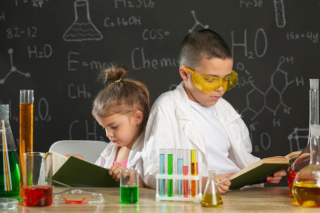Niños en laboratorio con libro estudiando