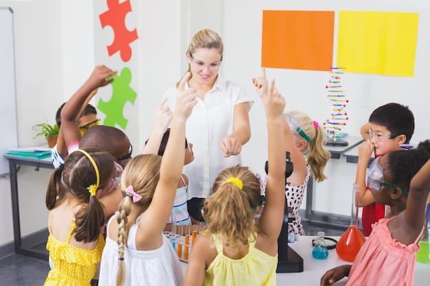 Niños levantando la mano en laboratorio