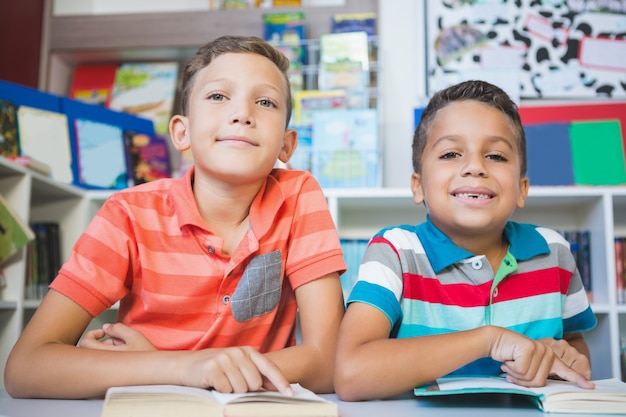 Niños leyendo el libro en la biblioteca