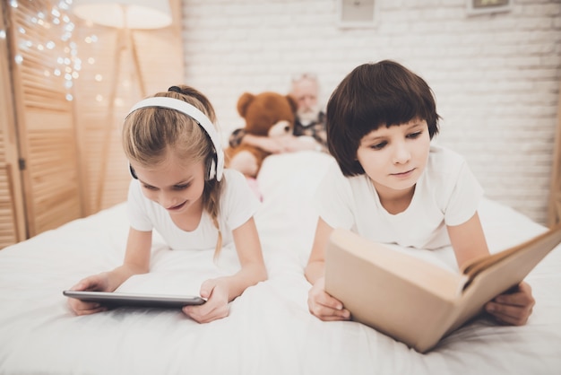 niños leyendo un libro en la cama