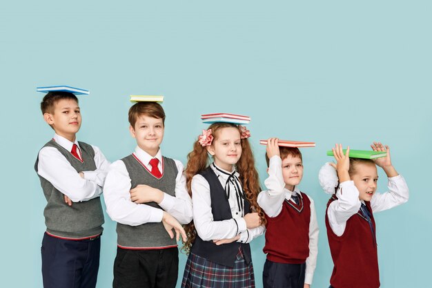 Niños con libros en el estudio sobre un fondo azul.