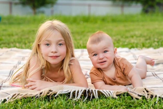 Niños lindos acostados en una manta en verano