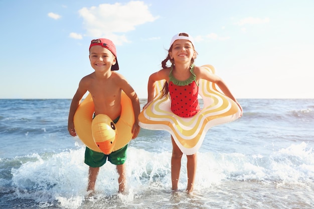 Niños lindos disfrutando de un día soleado en la playa Campamento de verano