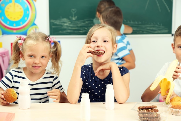 Niños lindos a la hora del almuerzo en el aula.