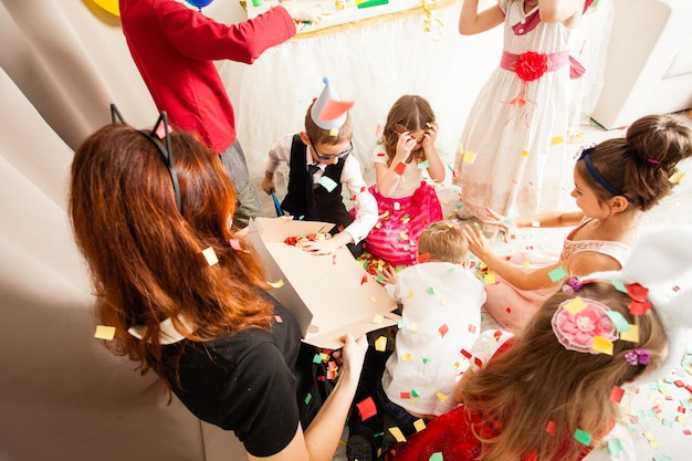 Niños lindos jugando con animador en la fiesta de cumpleaños. Mujer gato entretiene a los invitados