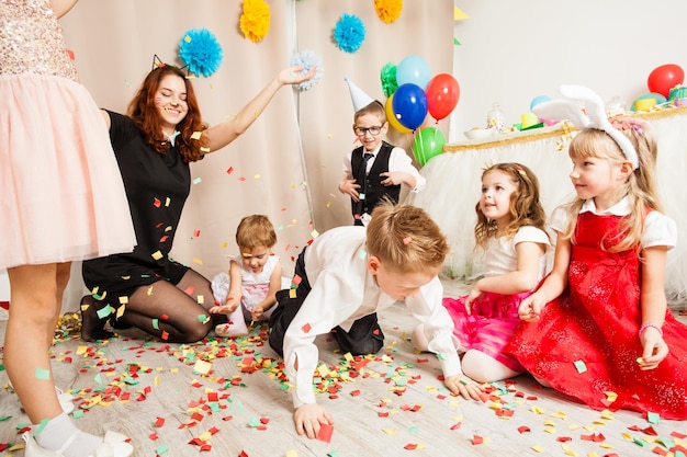 Niños lindos jugando con animador en la fiesta de cumpleaños. Mujer gato entretiene a los invitados