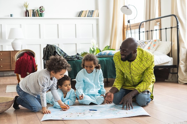 Niños lindos con el padre sentado en casa.