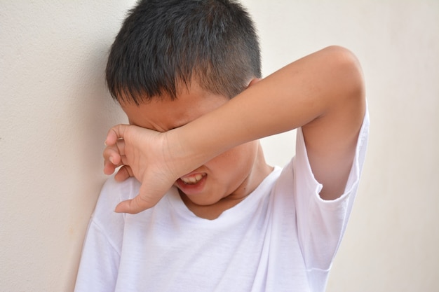 Los niños lloran frente a la pared.