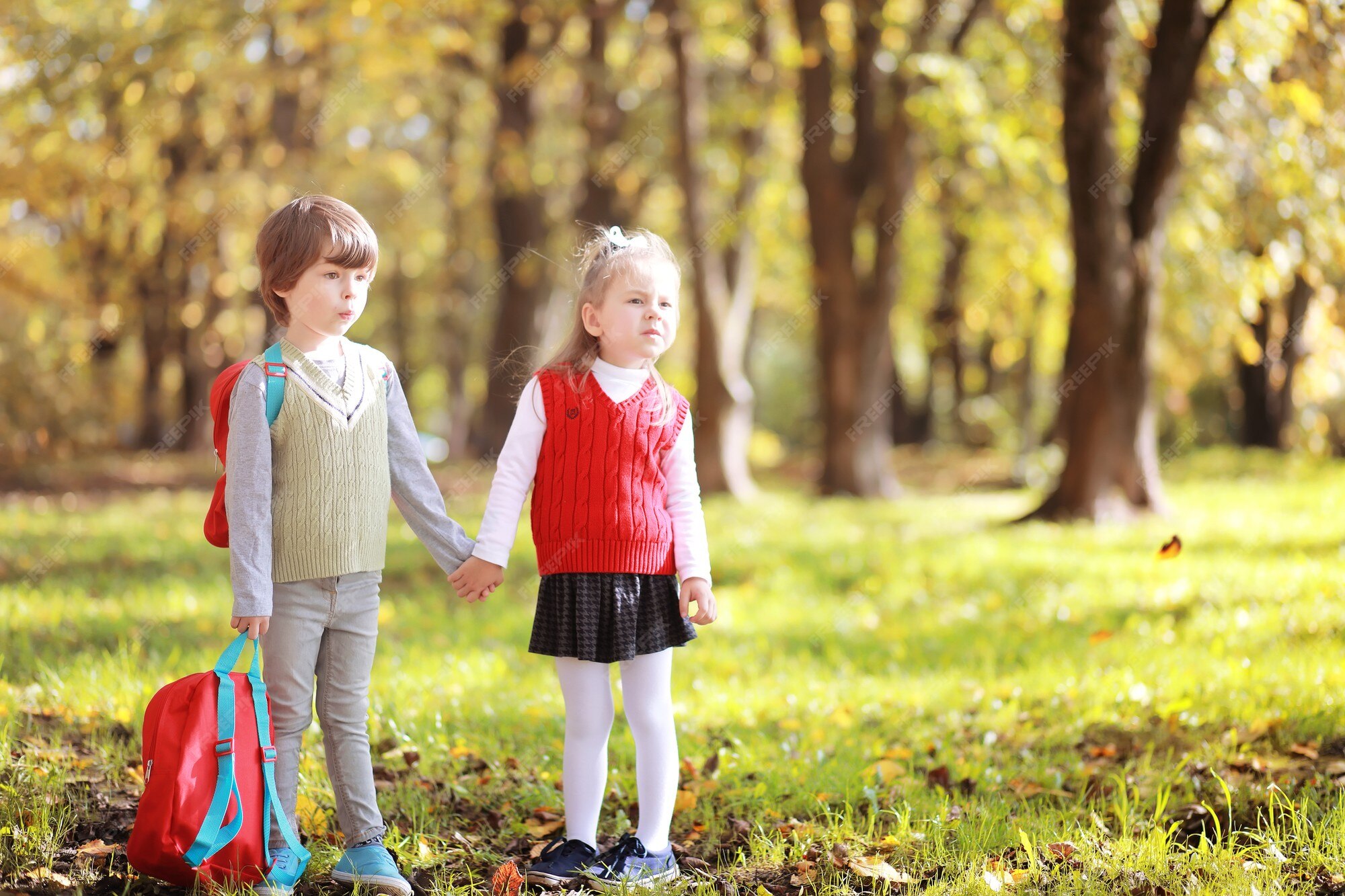 Niños con maletines para pasear por el parque. vacaciones escolares. el