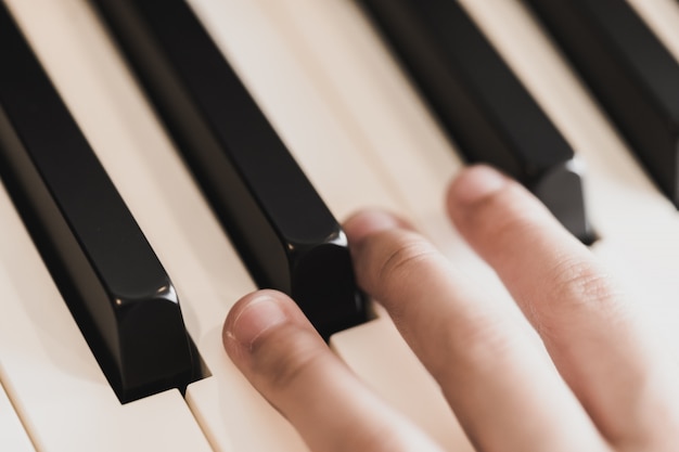 Niños manos sobre las teclas del piano tocando las teclas del piano