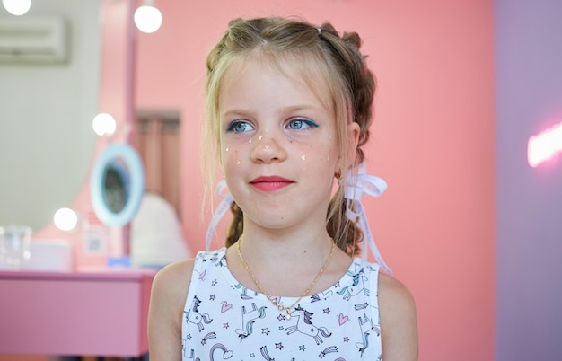 Los niños se maquillan Maquillaje con purpurina Destellos en la mejilla