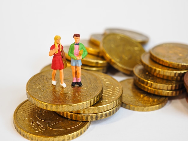 Los niños en miniatura se paran en monedas de Euro. Concepto de plan de dinero futuro familiar.