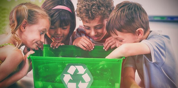 Niños mirando en caja verde.