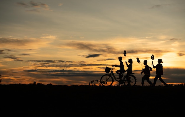 Niños montando bicicletas y corriendo a la luz temprana del día cuando el sol brilla