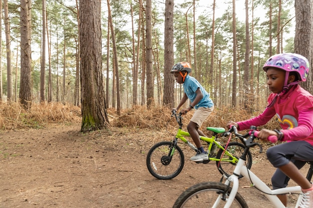 Niños montando su bicicleta en el bosque.