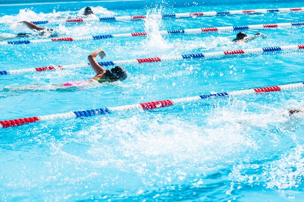 Los niños nadan en la piscina al aire libre durante el verano.