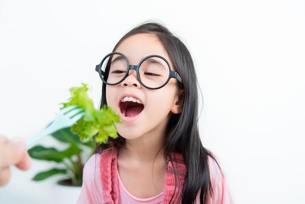 Niños niña asia comiendo verduras