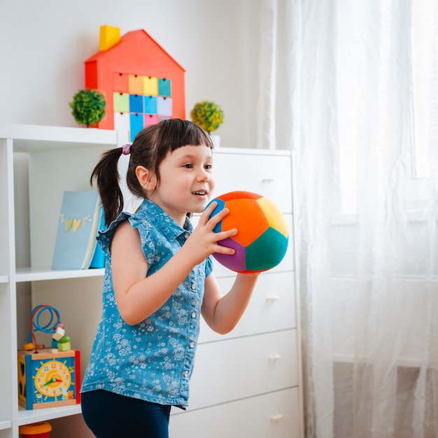 Los niños niña juegan sala de juegos infantiles, lanzando la pelota. concepto interacción padre e hijo