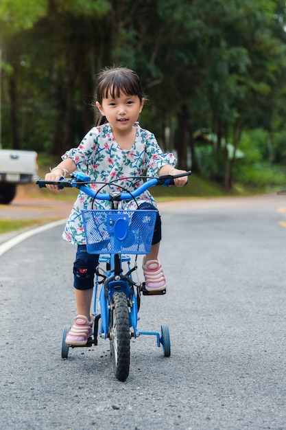 Foto los niños niña son andar en bicicleta en la carretera