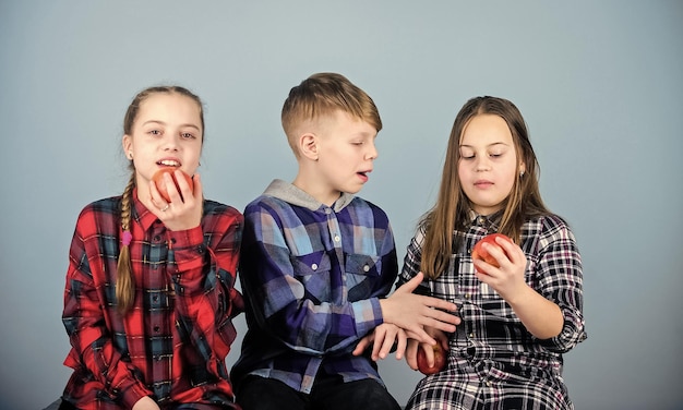 Niños y niñas amigos comen manzana Adolescentes con merienda saludable Grupo de adolescentes niños alegres sostienen manzanas Dieta saludable y nutrición vitamínica Comer fruta y ser saludable Promover una nutrición saludable