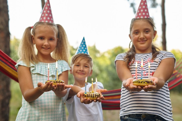 Niños y niñas celebrando un cumpleaños al aire libre en el jardín