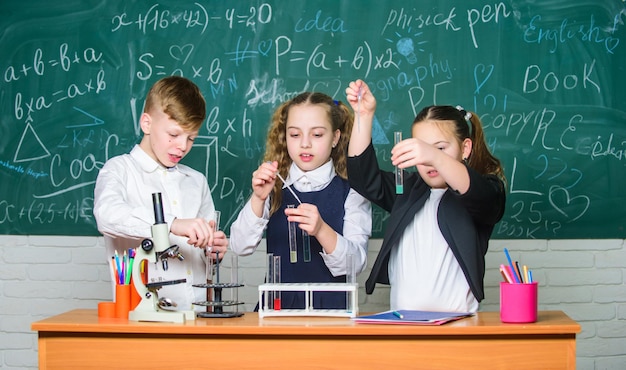 Niños y niñas disfrutan de un experimento químico La química orgánica es el estudio de compuestos que contienen carbono Reacciones químicas básicas Química fascinante Los alumnos de la escuela en grupo estudian química en la escuela