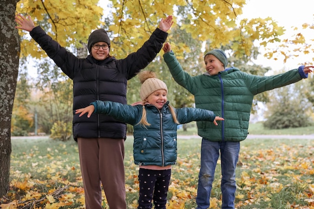 Niños y niñas felices disfrutan del día de otoño en el parque