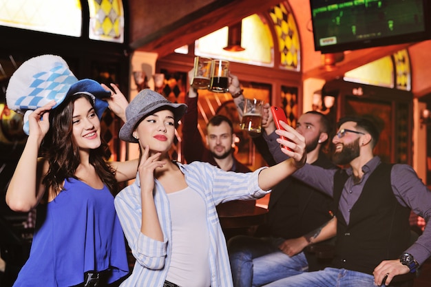 Niños y niñas con sombreros bávaros bebiendo cerveza