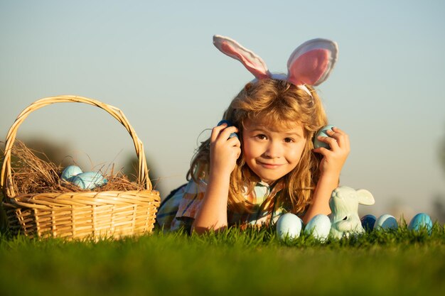 Niños, niño, cazar, huevos de pascua, en, parque, colocar, césped, en, cielo, plano de fondo, con, espacio de copia