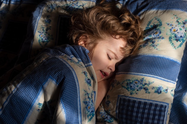 Niños niño pequeño duerme en la cama sobre la almohada