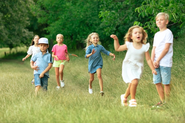 Niños, niños corriendo en la pradera, verano.