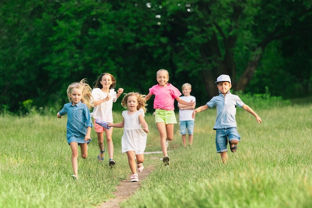 Niños, niños corriendo en la pradera, verano.