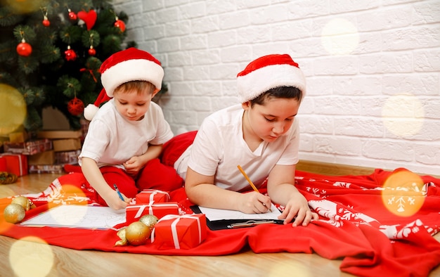 Foto niños niños escribe la carta a santa claus en casa interior