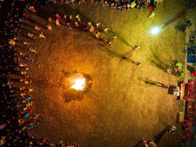 Niños, niños y niñas felices reunidos en grupo jugando alrededor de una fogata en el campo