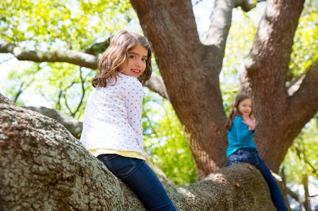 niños niños niñas jugando montando una rama de árbol