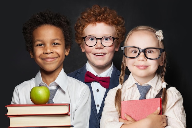 Niños, niños y niñas sonriendo sobre un fondo negro en el concepto de regreso a la escuela