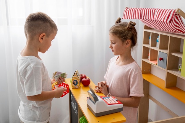 Foto niños no binarios jugando juntos en casa.